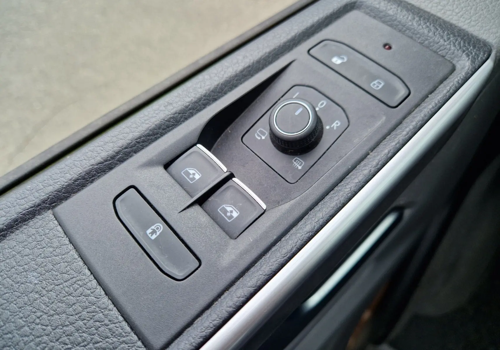 Gros plan sur les commandes de réglage des rétroviseurs et des vitres côté conducteur du Volkswagen California Cooper bronze 2021.