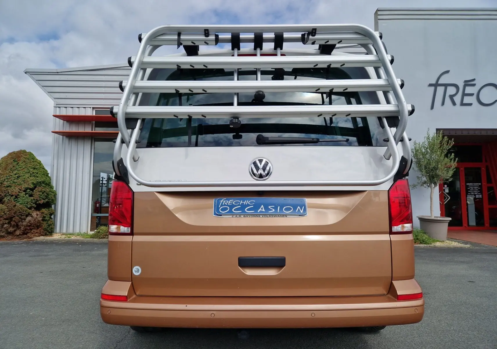 Vue arrière d'un Volkswagen California Cooper bronze 2021 avec porte-bagages métallique et plaque d'occasion.