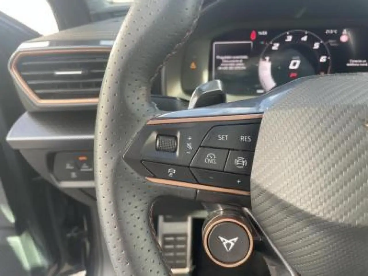 Gros plan sur le volant perforé et les commandes du tableau de bord digital du CUPRA Leon 2025.