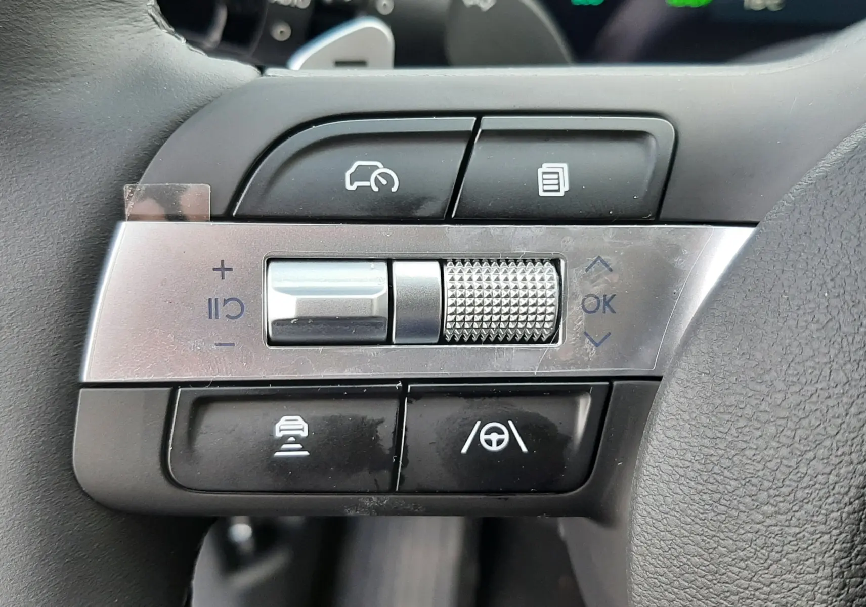 Gros plan sur les commandes de régulateur de vitesse et assistance au volant du Hyundai Tucson 2025, volant cuir noir.