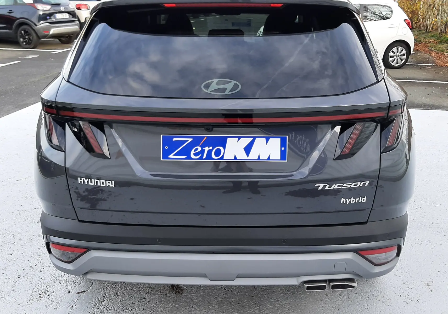Vue arrière d'un Hyundai Tucson hybride gris Ecotronic avec feux LED et double sortie d'échappement carrée.