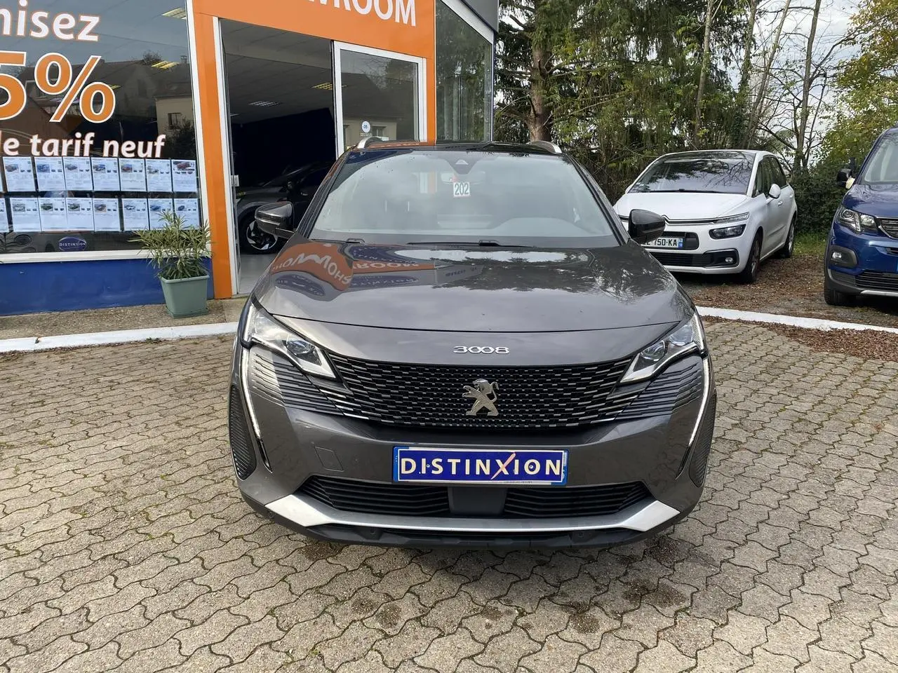 Peugeot 3008 gris foncé vue de face, mettant en valeur sa calandre GT et ses projecteurs LED distinctifs.