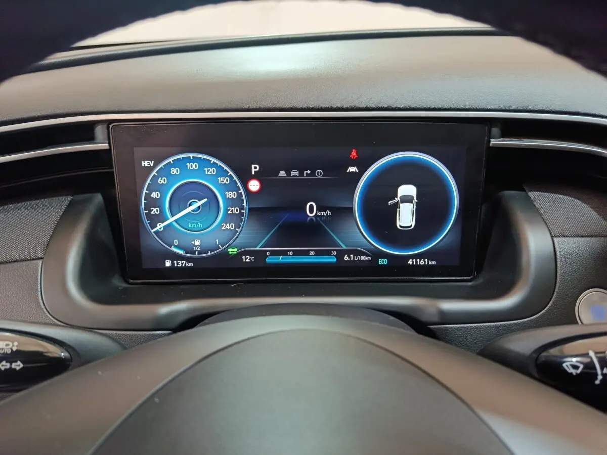 Tableau de bord numérique du Hyundai Tucson 2022, affichage 10,3 pouces avec indicateurs vitesse et porte ouverte.