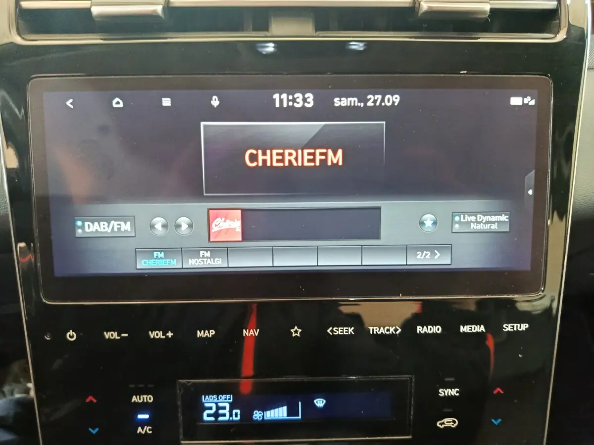 Écran tactile central du Hyundai Tucson marron 2022 affichant la radio CHERIE FM et commandes multimédia.