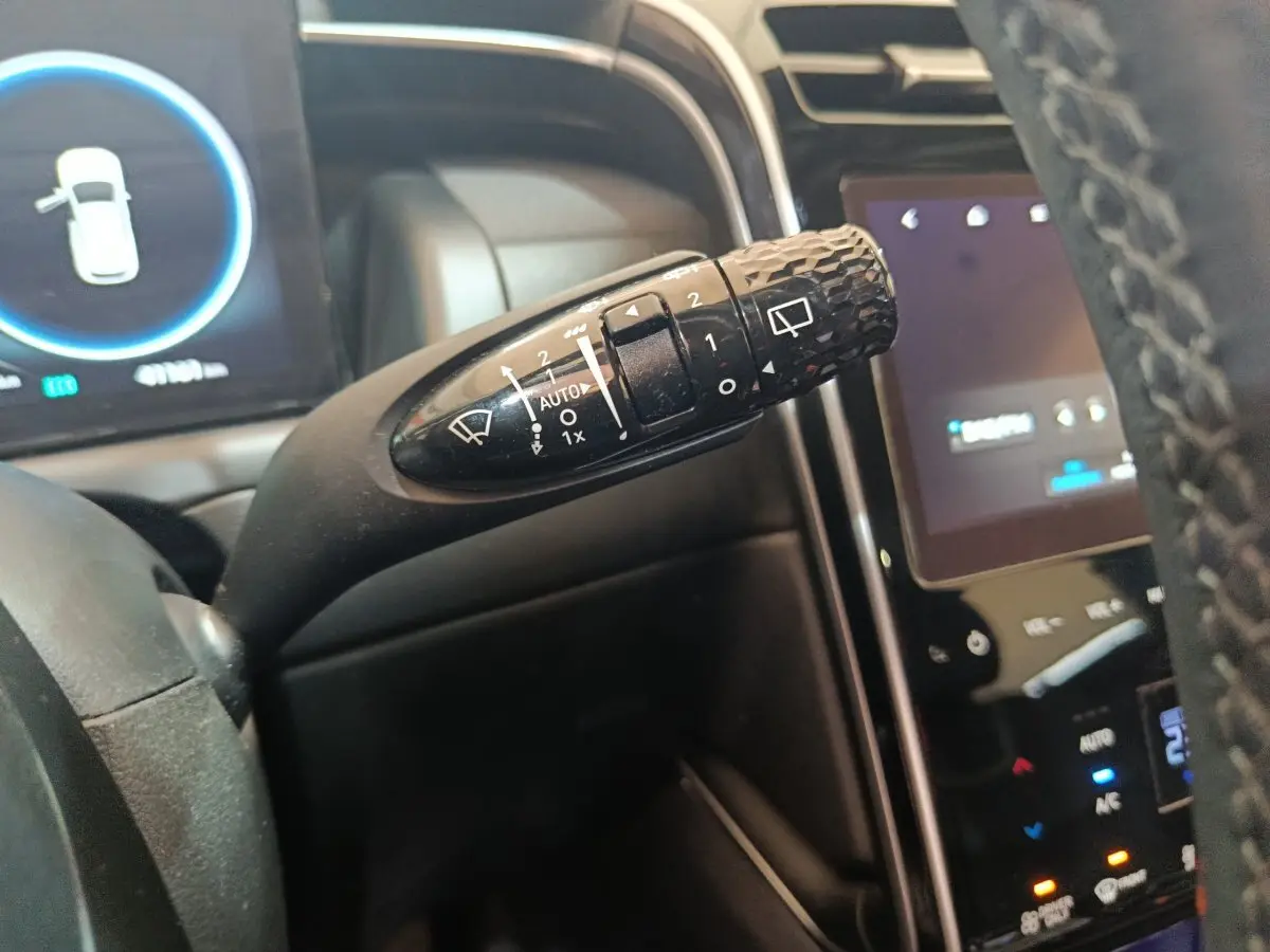 Gros plan sur la commande d'essuie-glace noire à motifs, tableau de bord et écran tactile du Hyundai Tucson marron 2022.