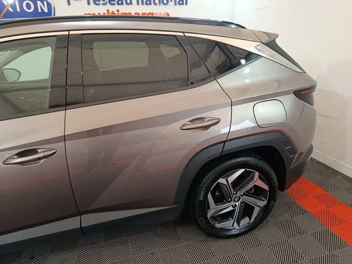 Vue latérale droite du Hyundai Tucson marron 2022, mettant en valeur la portière arrière et la jante au design moderne.