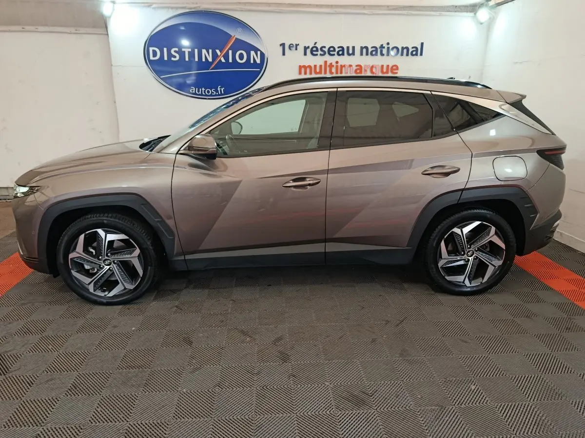 Profil droit d'un Hyundai Tucson marron 2022 hybride rechargeable avec jantes alliage et lignes anguleuses marquées.