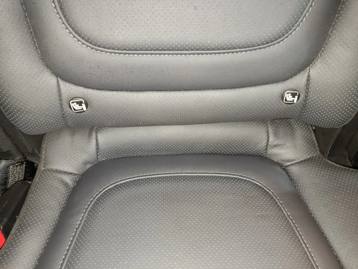 Gros plan sur la partie inférieure d'un siège arrière en cuir noir avec indicateurs Isofix visibles.