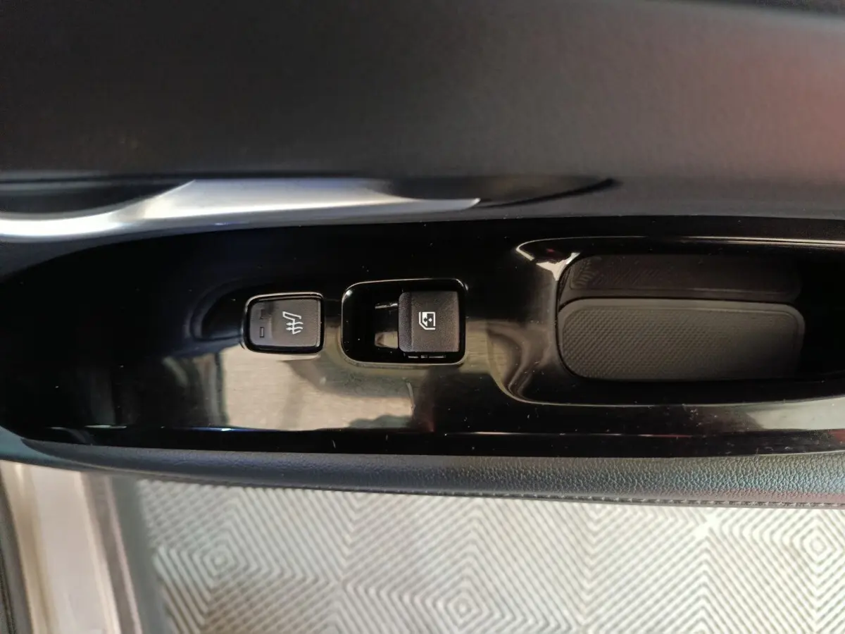 Gros plan sur les commandes de verrouillage et désembuage sur la porte intérieure côté conducteur du Hyundai Tucson marron 2022.