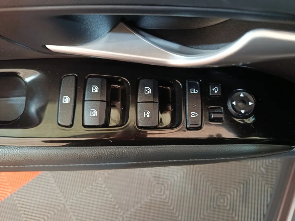 Vue rapprochée du panneau de commandes des vitres et rétroviseurs côté conducteur du Hyundai Tucson marron 2022.