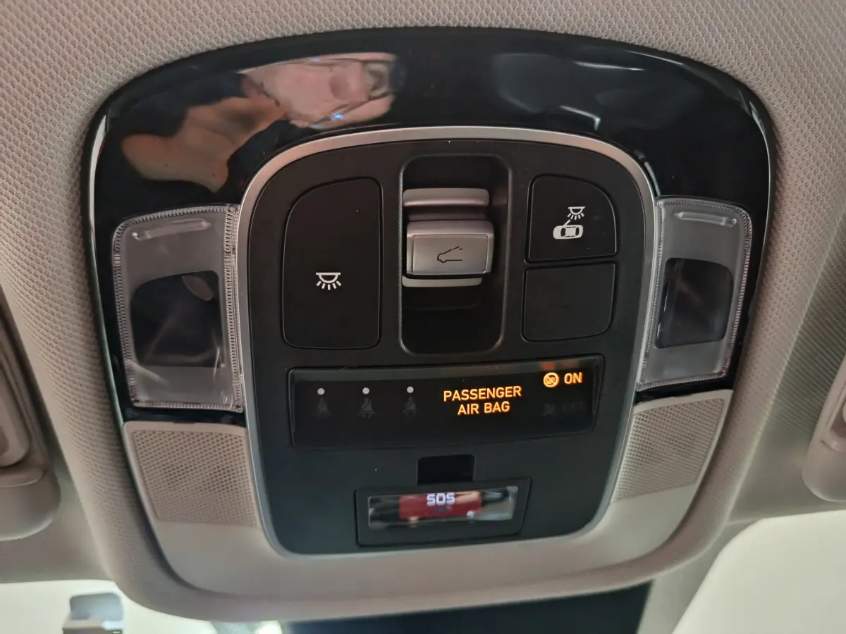 Vue en gros plan du panneau de commandes au plafond avec indicateur airbag passager allumé dans un Hyundai Tucson 2022 marron.