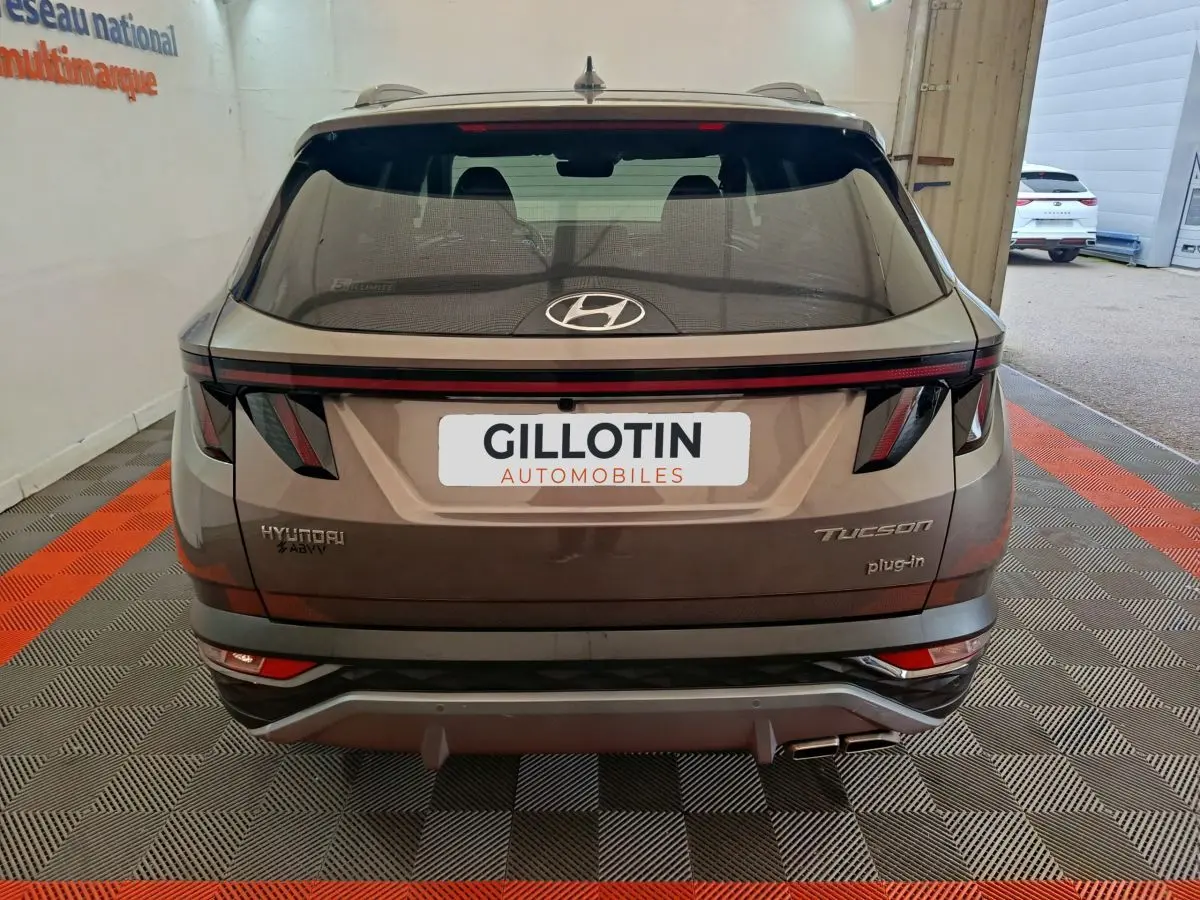 Vue arrière du Hyundai Tucson marron 2022 avec feux LED et logo plug-in hybride visible sur le hayon.