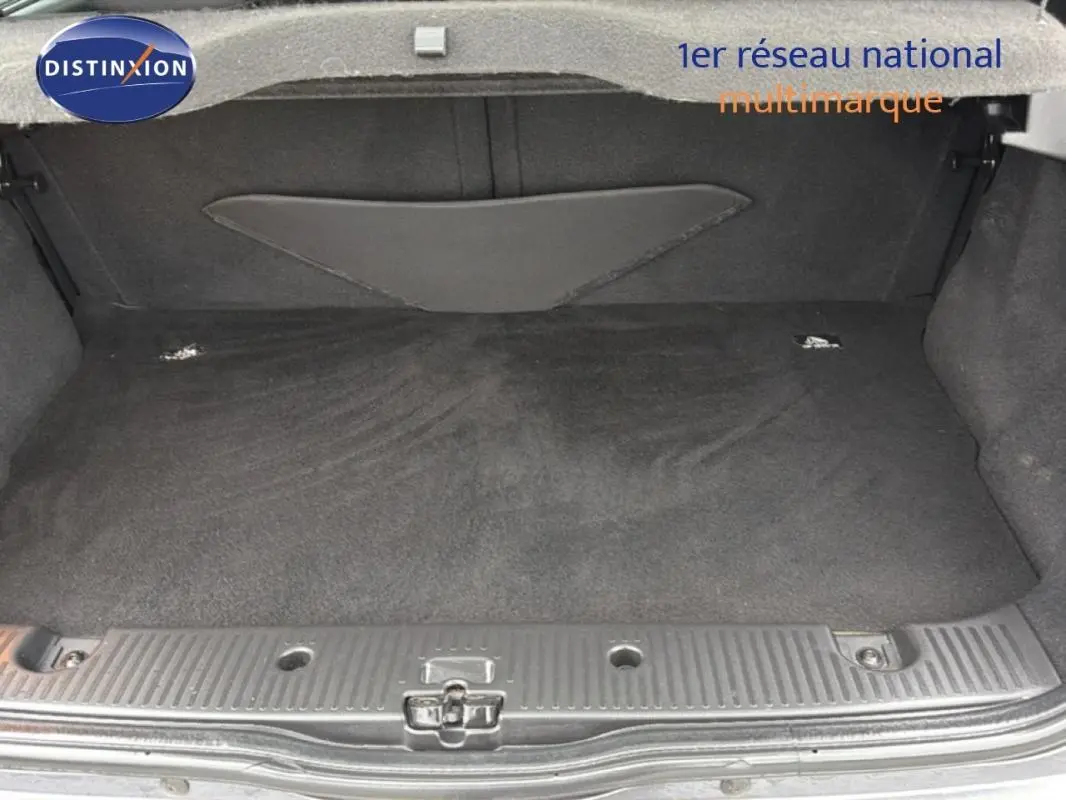 Coffre ouvert de Renault Twingo III gris foncé, vue de l'arrière montrant l'espace de chargement vide et la moquette noire.