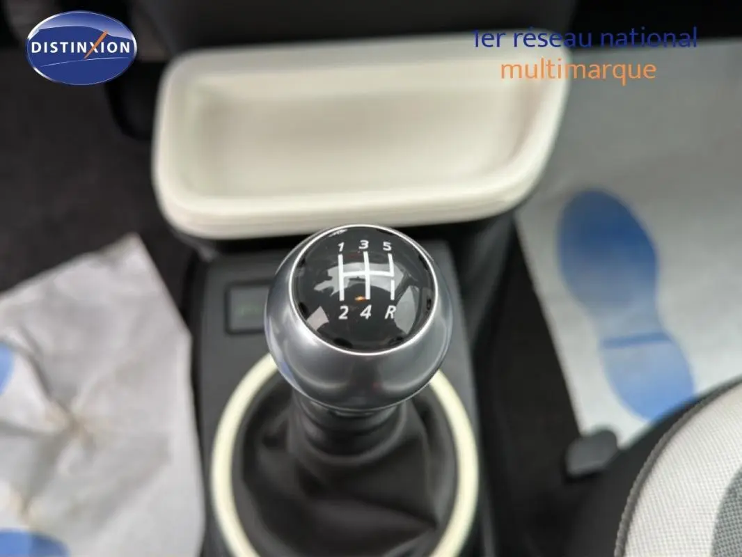 Gros plan sur le levier de vitesses manuel de la Renault Twingo III gris foncé, intérieur clair avec console beige.