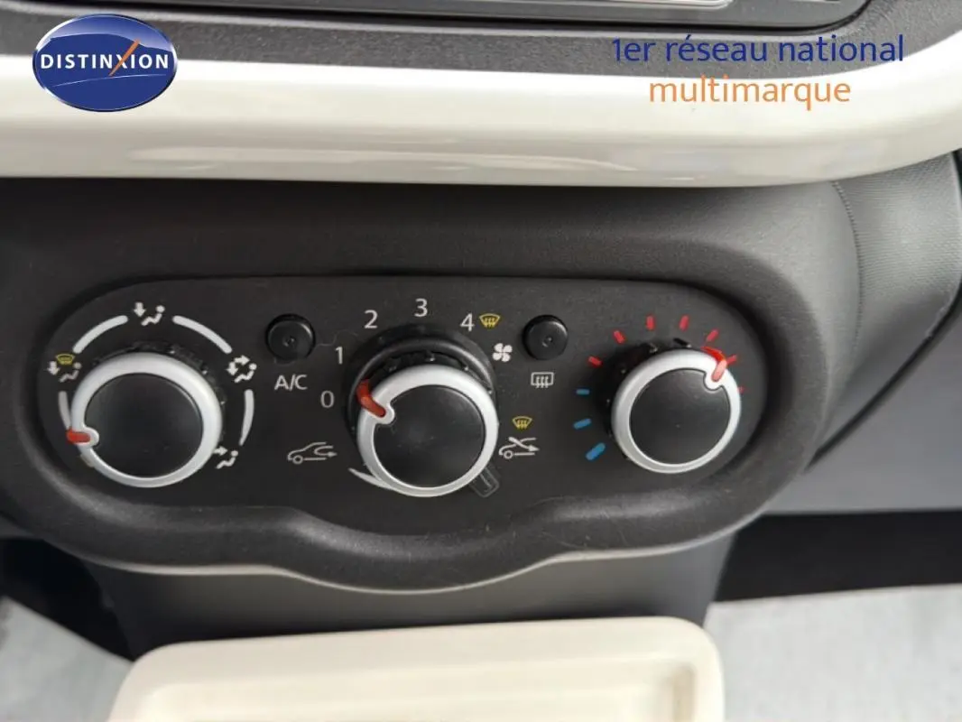 Vue rapprochée des commandes de climatisation manuelle sur tableau de bord noir de Renault Twingo gris foncé.
