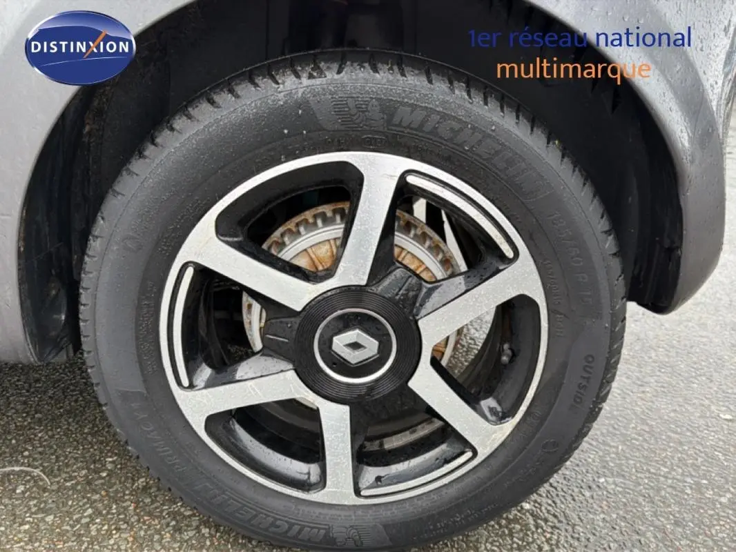 Gros plan sur la jante alliage 15 pouces noire et grise d'une Renault Twingo III gris foncé, avec logo central Renault.