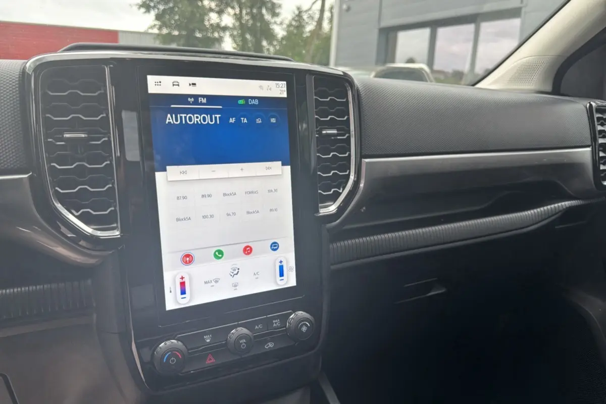 Vue rapprochée de la console centrale du Ford Ranger 2026, écran tactile vertical et tableau de bord noir.