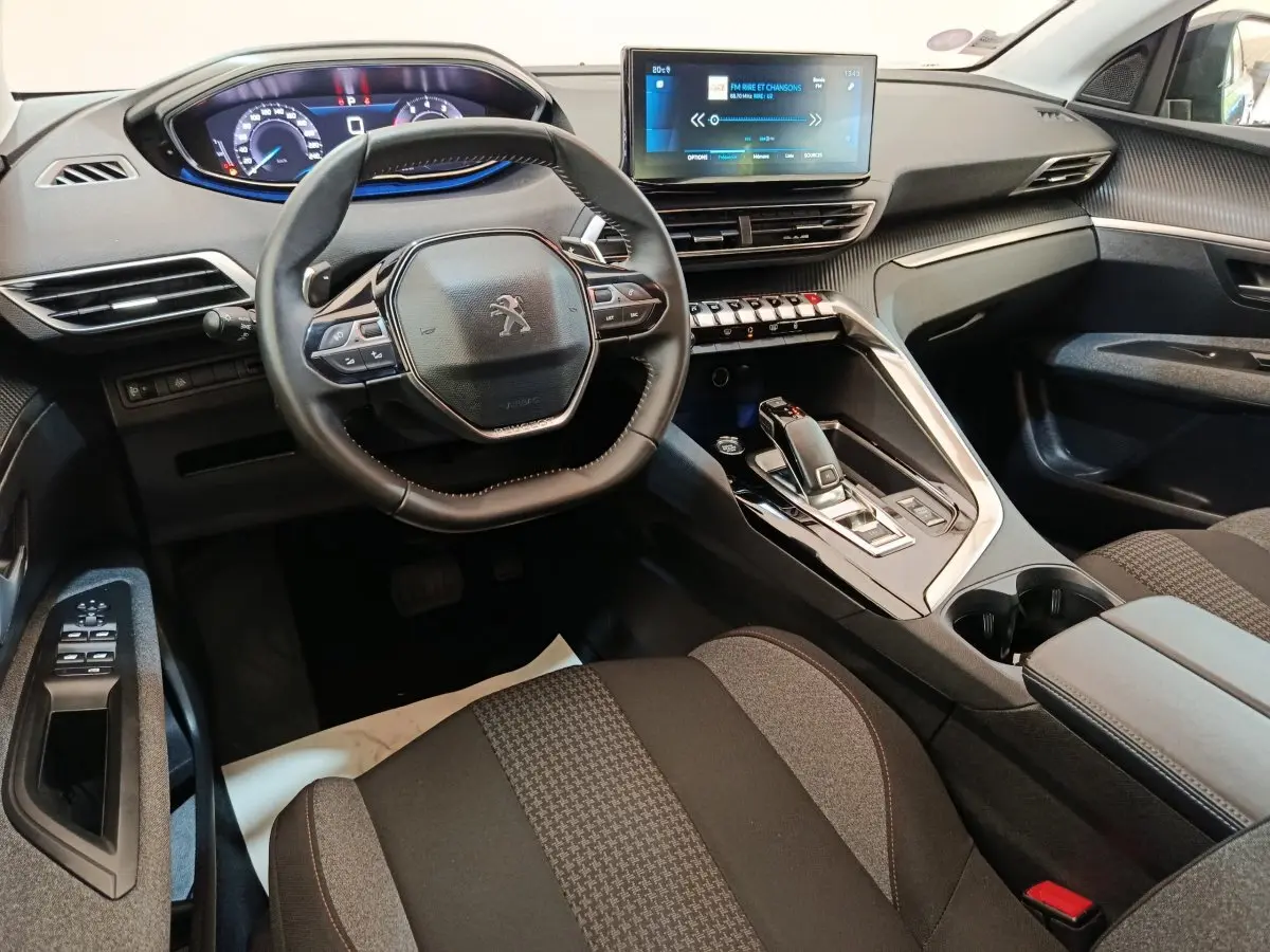 Intérieur Peugeot 3008 2022 vu côté conducteur, volant cuir, tableau de bord digital et écran tactile central.