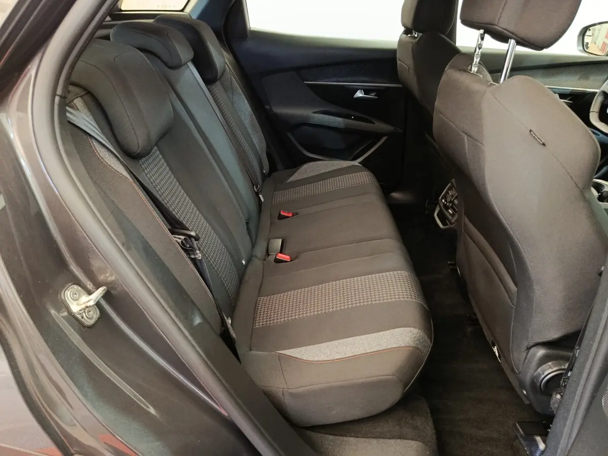 Vue intérieure côté gauche des sièges arrière gris foncé du Peugeot 3008 2022, avec détails de tissu et appuie-têtes.