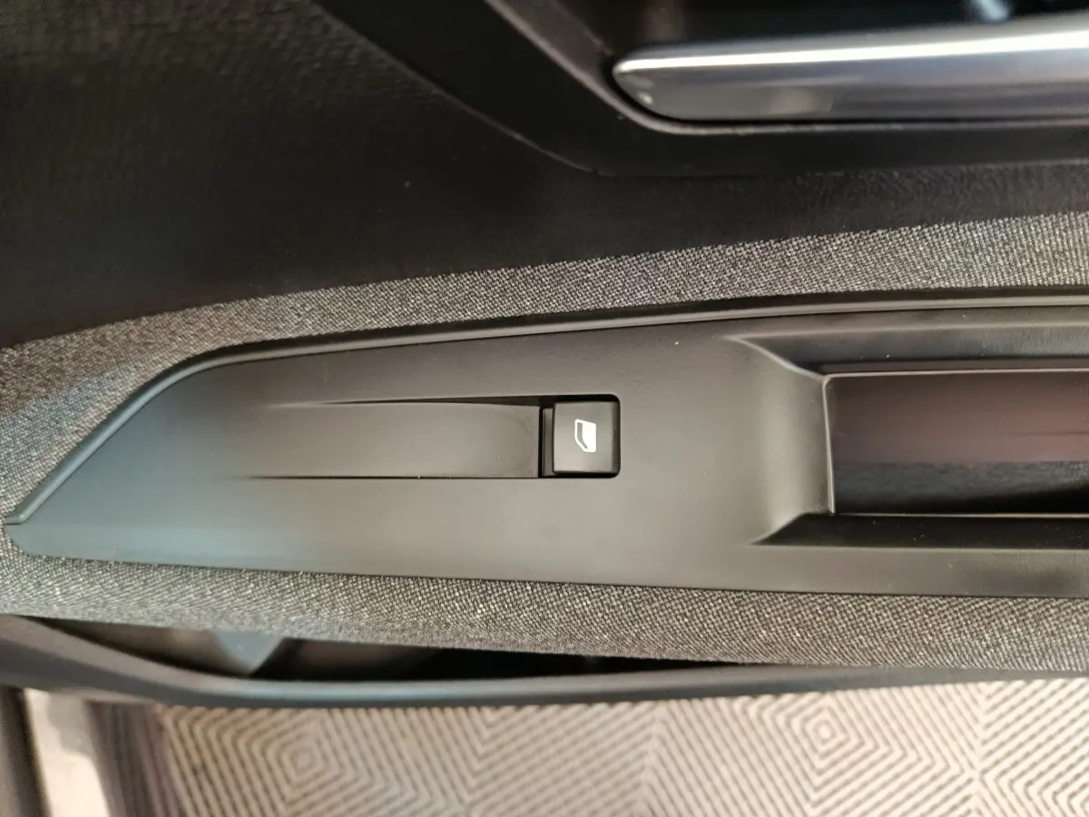Gros plan sur le bouton de commande de la ventilation additionnelle côté passager du Peugeot 3008 gris foncé, intérieur tissu noir.