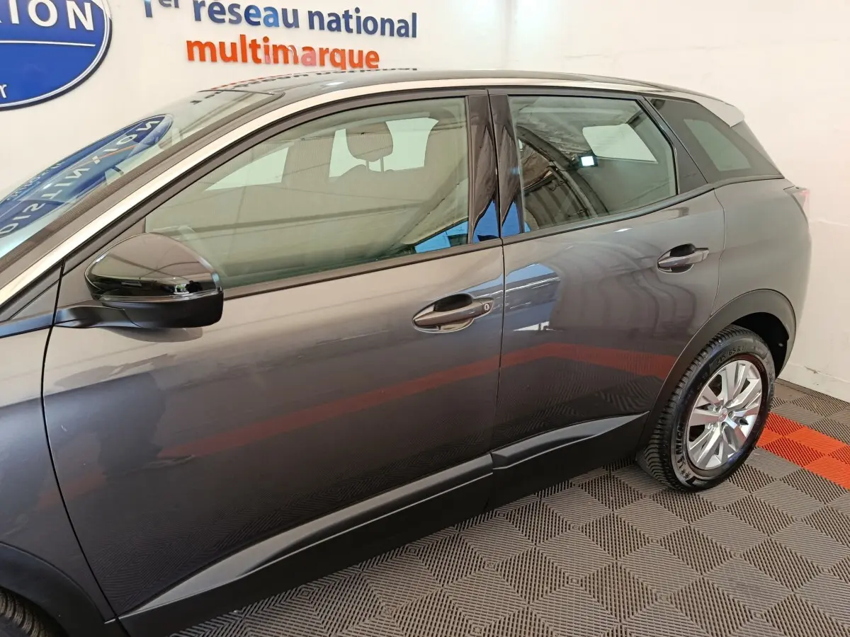 Vue latérale côté gauche du Peugeot 3008 gris foncé, mettant en valeur les lignes épurées et les rétroviseurs électriques.