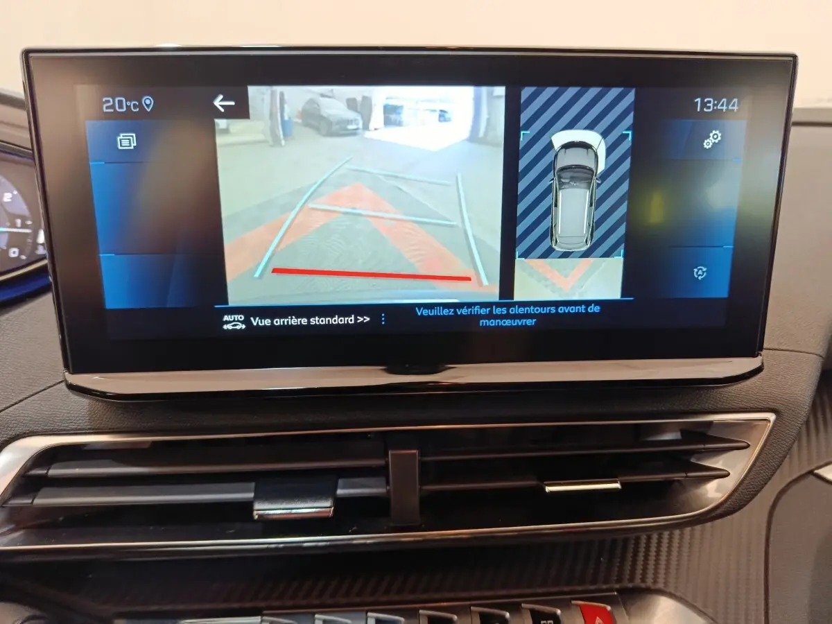 Écran tactile du tableau de bord du Peugeot 3008 gris foncé affichant la caméra de recul et l’aide au stationnement.