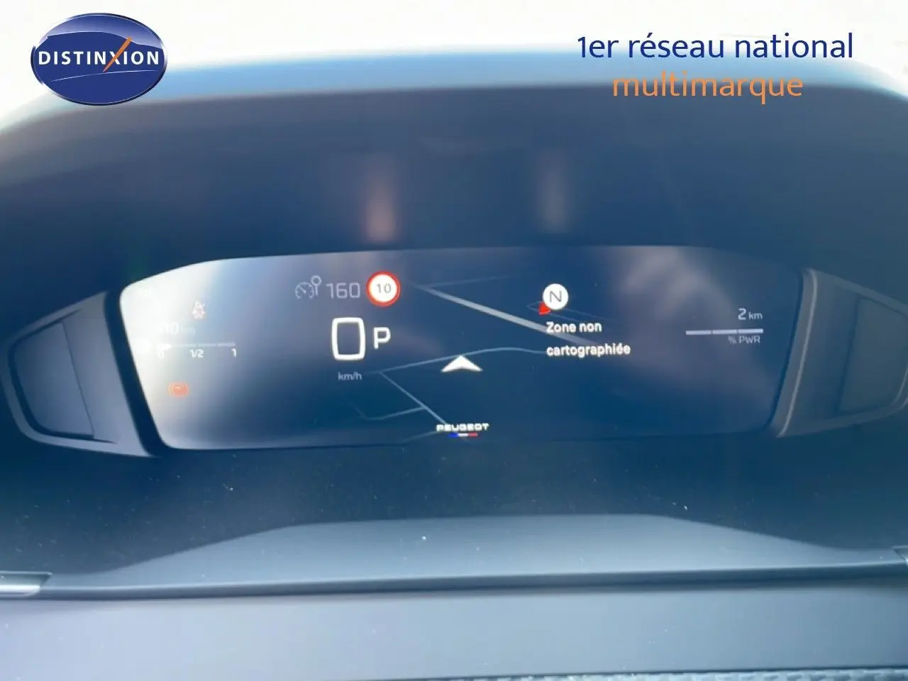 Tableau de bord numérique de la Peugeot 208 Hybrid 110ch, affichant la navigation et la vitesse en mode parking.