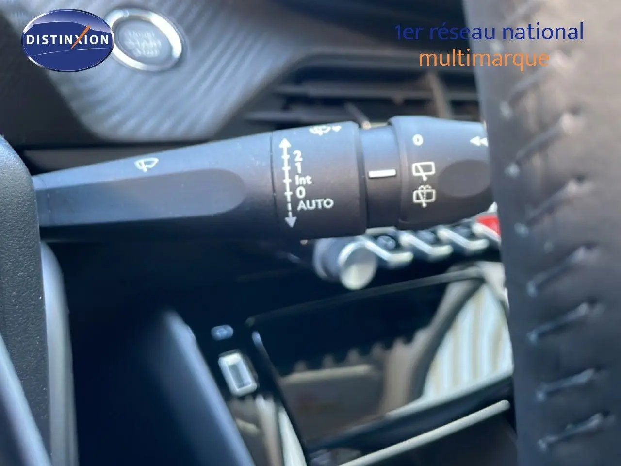 Gros plan sur la commande d'essuie-glace à gauche du volant d'une Peugeot 208 jaune Agueda Metal de 2026.