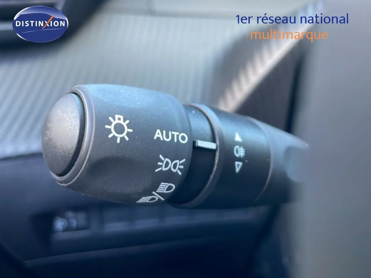 Gros plan sur la commande des feux automatique dans l’habitacle d’une Peugeot 208 Hybrid jaune Agueda Metal.