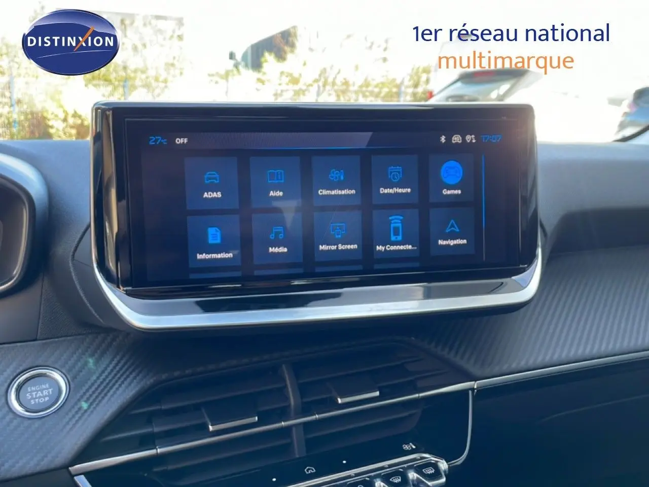 Vue intérieure centrée sur l'écran tactile du tableau de bord de la Peugeot 208 hybride, avec finition carbone et bouton start/stop visible.