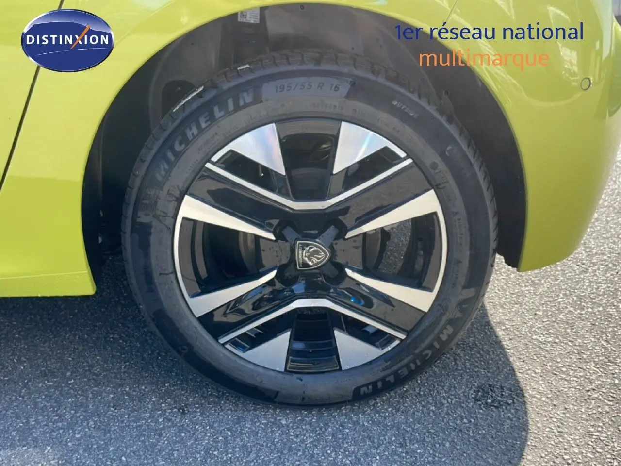 Gros plan sur la roue avant gauche d'une Peugeot 208 jaune Agueda Metal avec jante alliage noire et argentée.