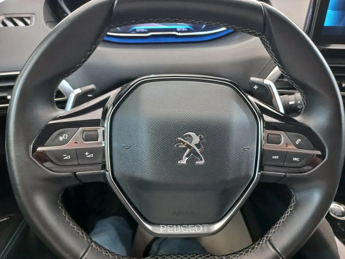 Volant cuir noir de Peugeot 5008 PureTech 130 2021 vu de face avec commandes intégrées et logo lion central.