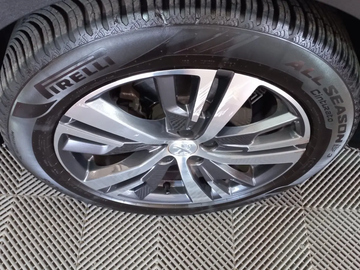 Gros plan sur la jante alliage gris foncé avec logo Peugeot et pneu Pirelli All Season sur Peugeot 5008 2021