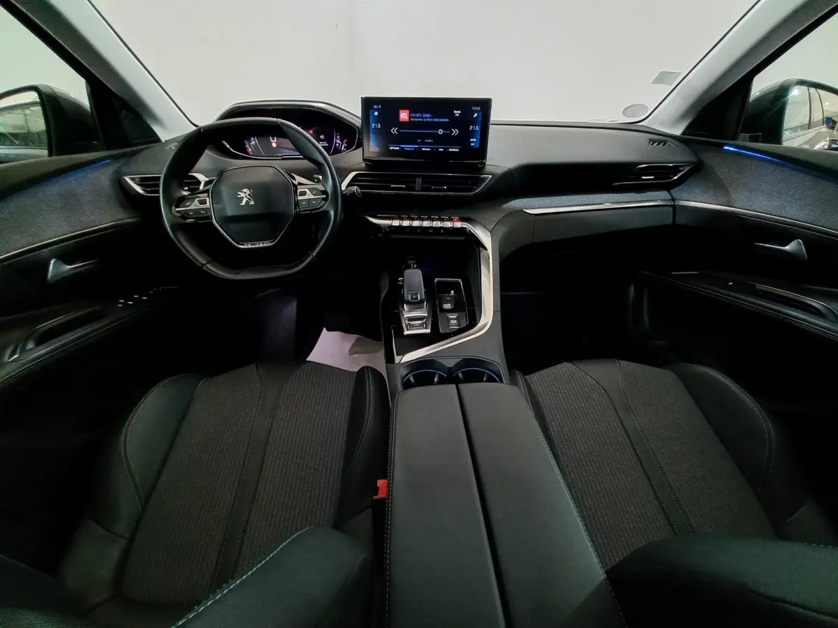 Intérieur Peugeot 5008 2021 vu de face, tableau de bord moderne avec écran tactile et volant cuir noir.