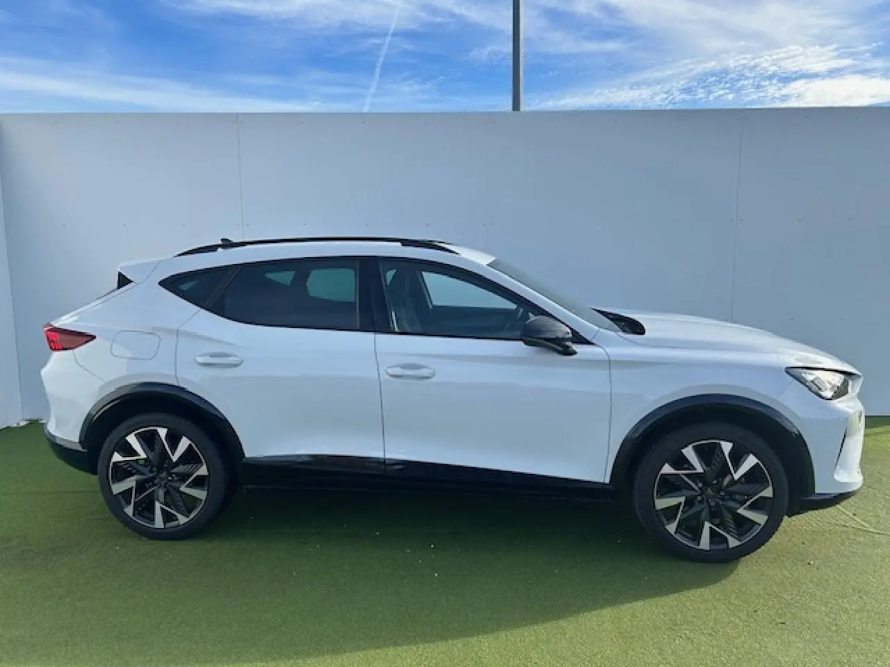 Vue de profil côté gauche du CUPRA Formentor blanc neige avec jantes alliage 19'' Sandstorm et détails noirs contrastants.