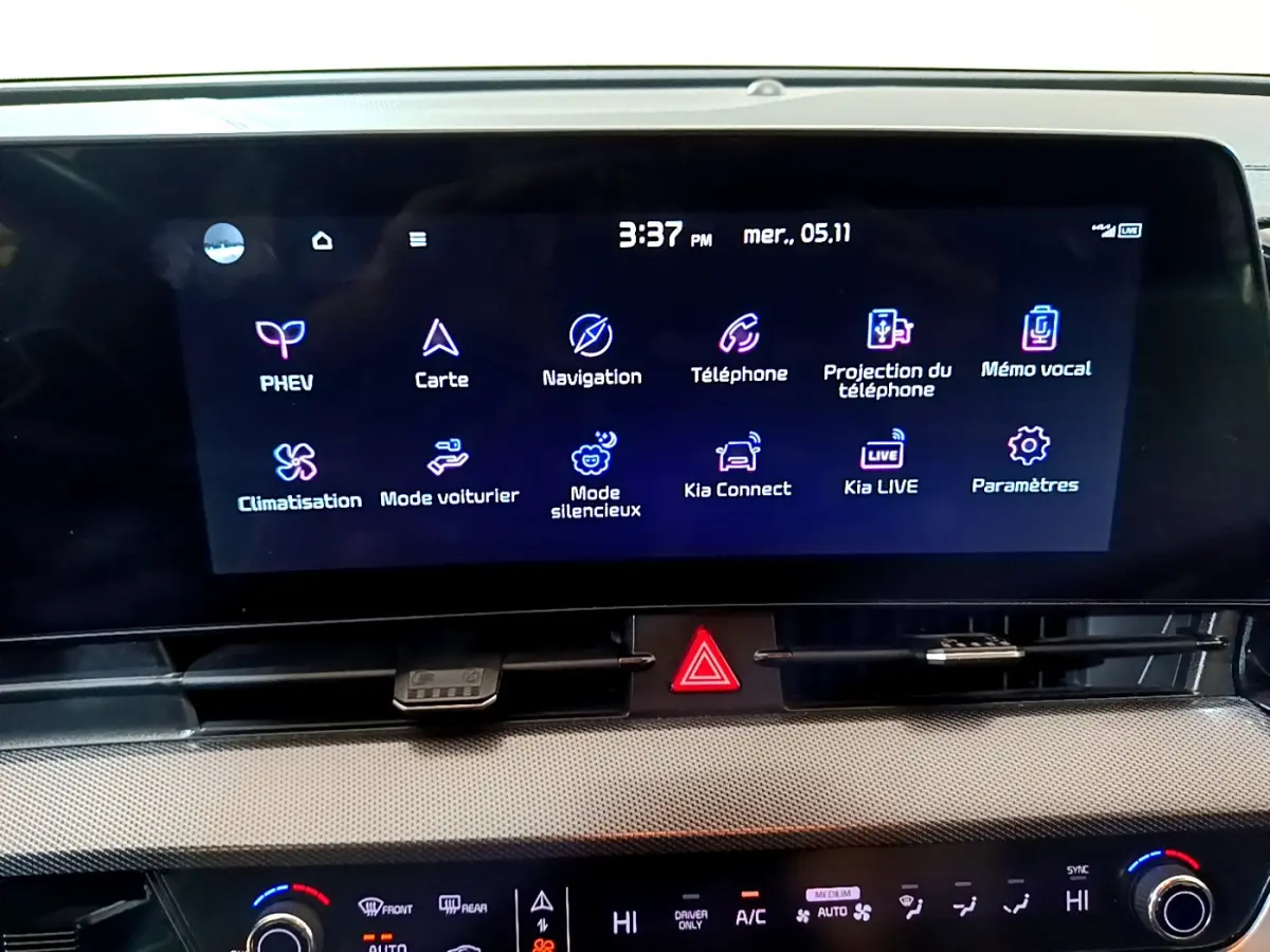 Écran tactile central du tableau de bord du Kia Sportage blanc 2022, affichant les options connectées et climatisation.