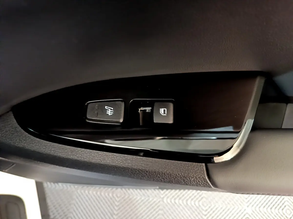 Gros plan sur les commandes de réglage des rétroviseurs côté conducteur du Kia Sportage blanc 2022.