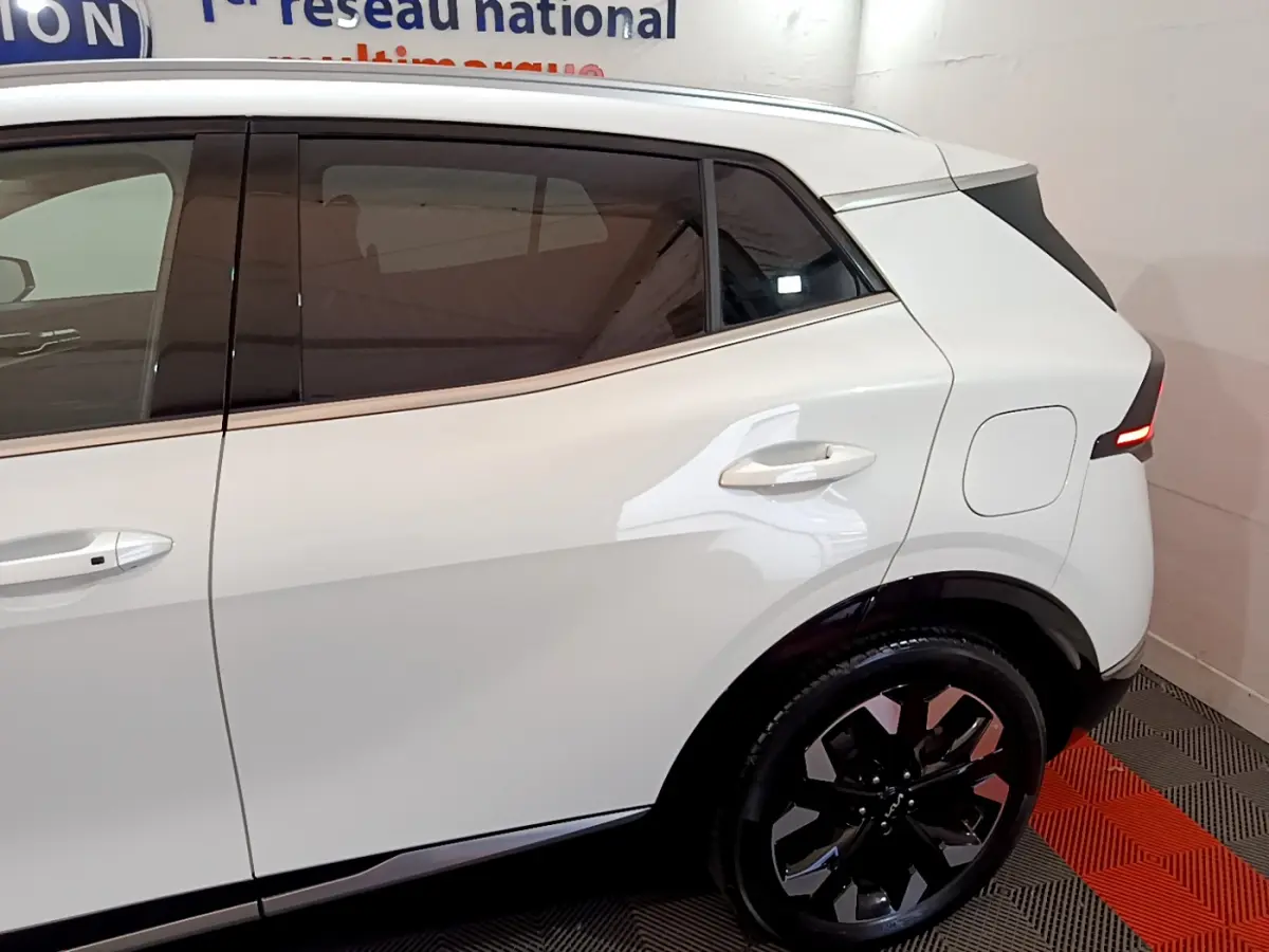 Vue latérale droite du KIA SPORTAGE blanc 2022, mettant en valeur les vitres teintées et la jante noire design.