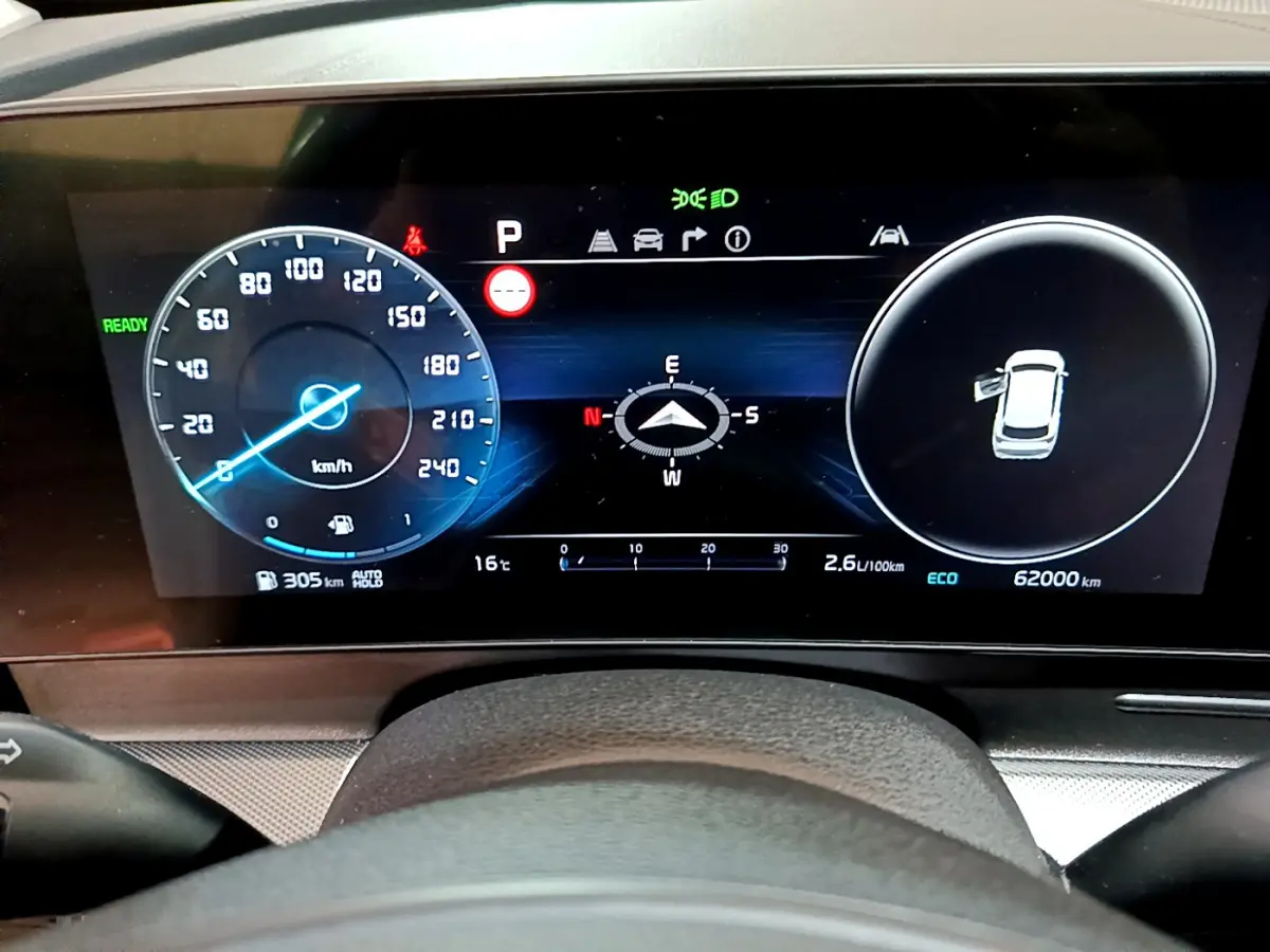 Affichage numérique du tableau de bord du Kia Sportage 2022 avec vitesse, boussole et état porte ouverte.