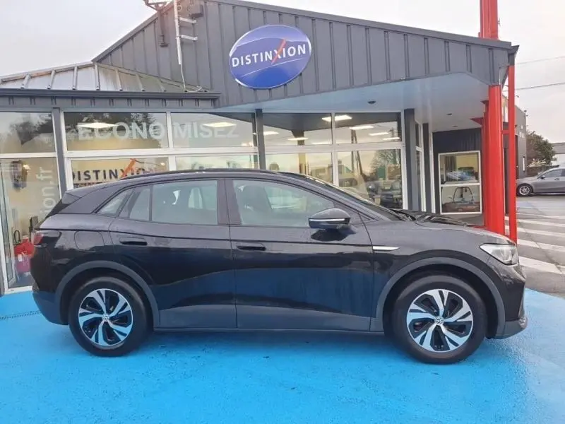 Profil droit du Volkswagen ID.4 148ch Pure noir ébène métallisé, avec jantes alu et lignes épurées.