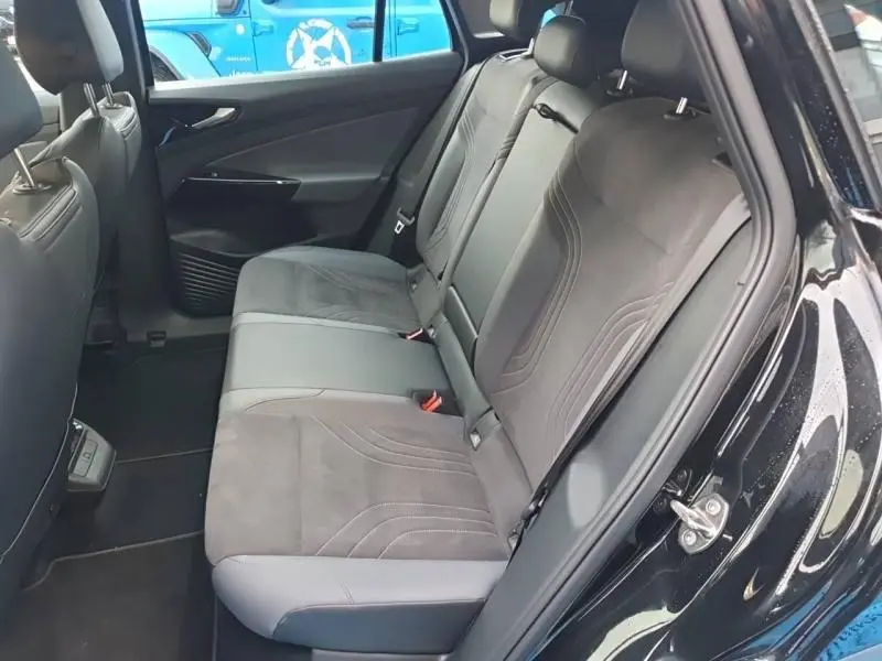 Vue intérieure côté droit montrant la banquette arrière en tissu gris et simili cuir du Volkswagen ID.4 noir Ebène métallisé.