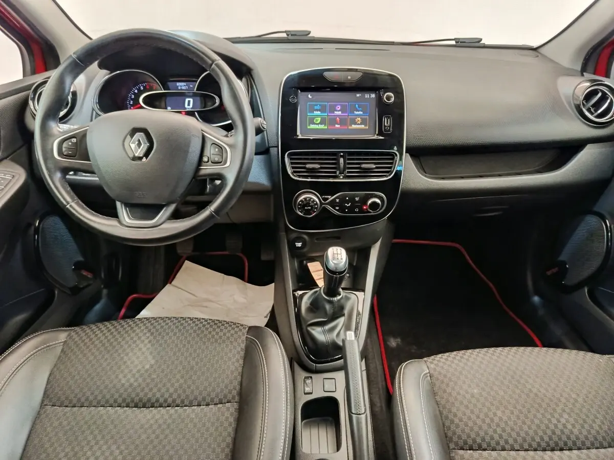 Vue intérieure avant de la Renault Clio Intens rouge, avec volant cuir multifonctions et écran tactile central 7 pouces.