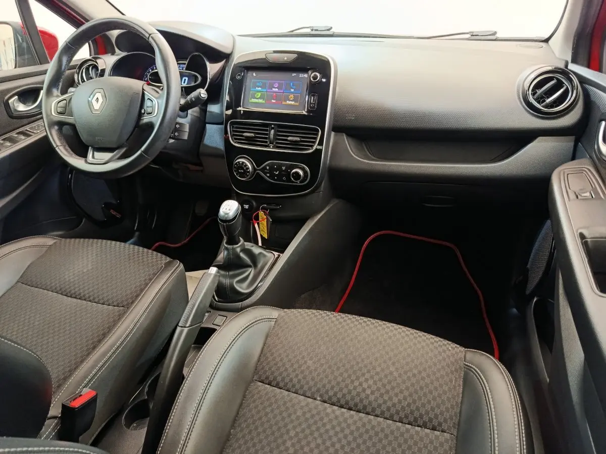 Intérieur de Renault Clio Intens 2018, vue avant centrée sur tableau de bord et boîte manuelle, sièges noirs.