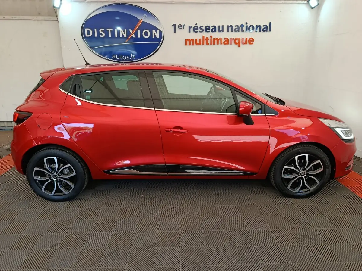 Profil droit d'une Renault Clio Intens Energy TCe 90 rouge de 2018, avec jantes alliage et poignées de porte intégrées.
