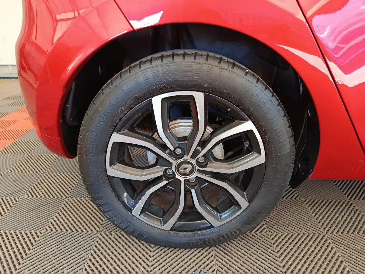Gros plan sur la roue arrière droite rouge d'une Renault Clio Intens Energy TCe 90 avec jante alliage noire et argent.