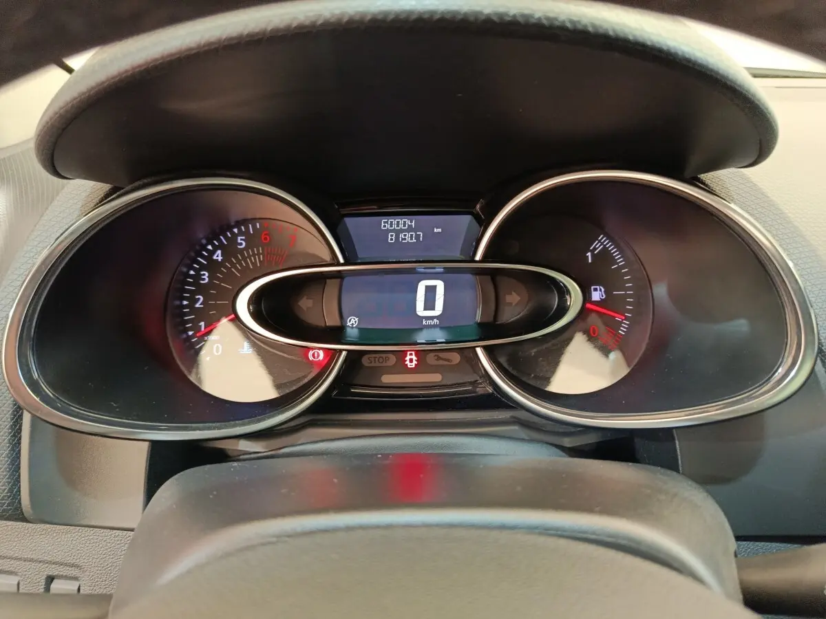Vue rapprochée du tableau de bord de la Renault Clio rouge 2018, affichant le compteur digital et les compte-tours.