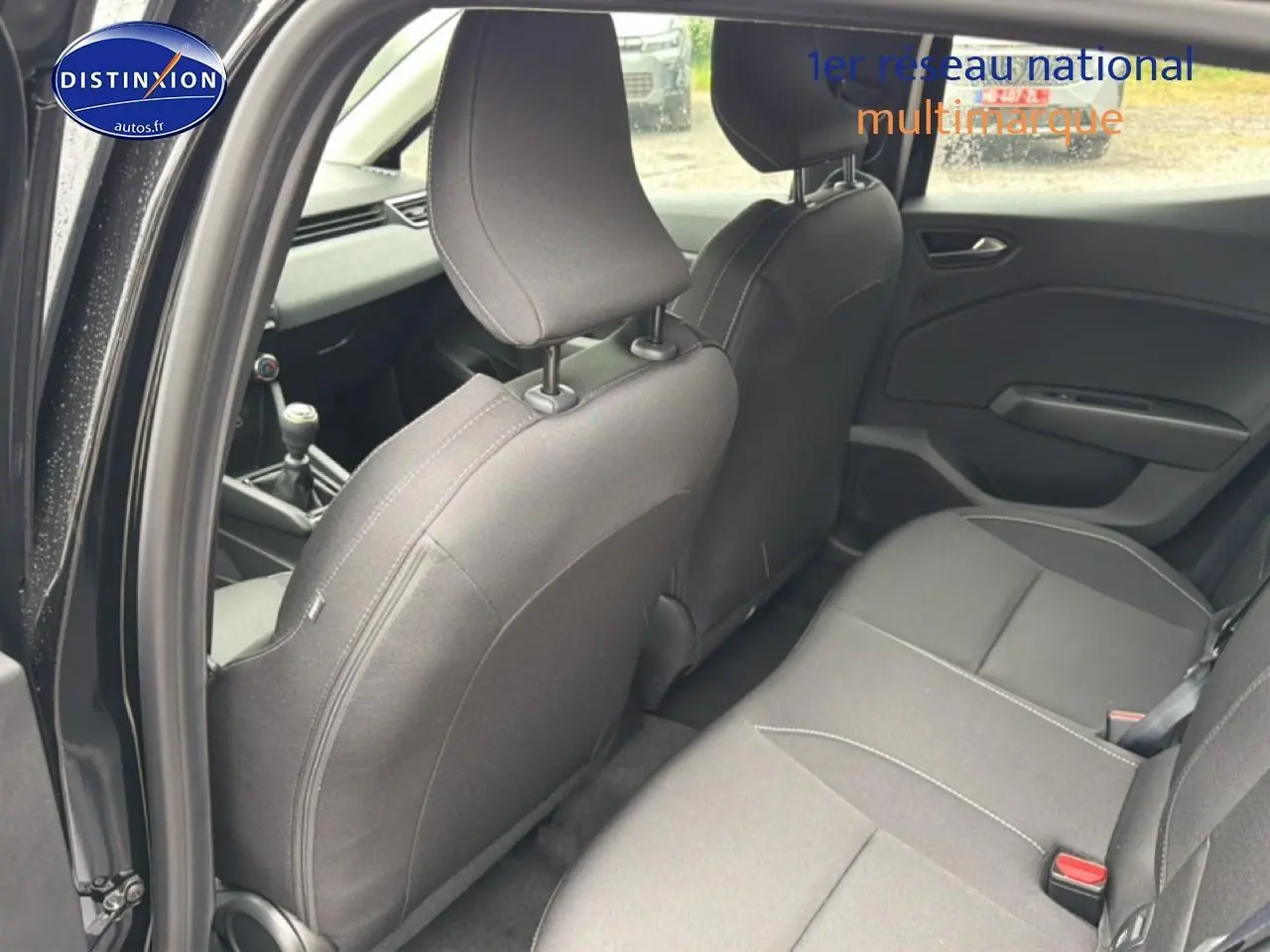 Vue intérieure côté gauche montrant la banquette arrière noire et les sièges avant d'une Renault Clio V 1.0 TCe 90 Evolution.