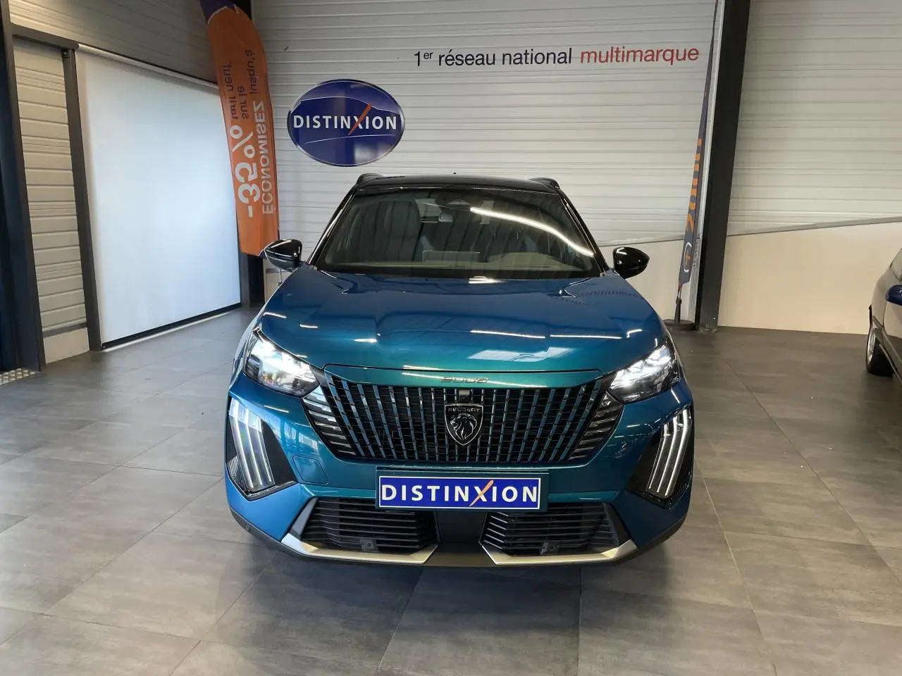 Vue avant d'un Peugeot 2008 bleu métallisé avec calandre noire et feux LED en showroom intérieur.
