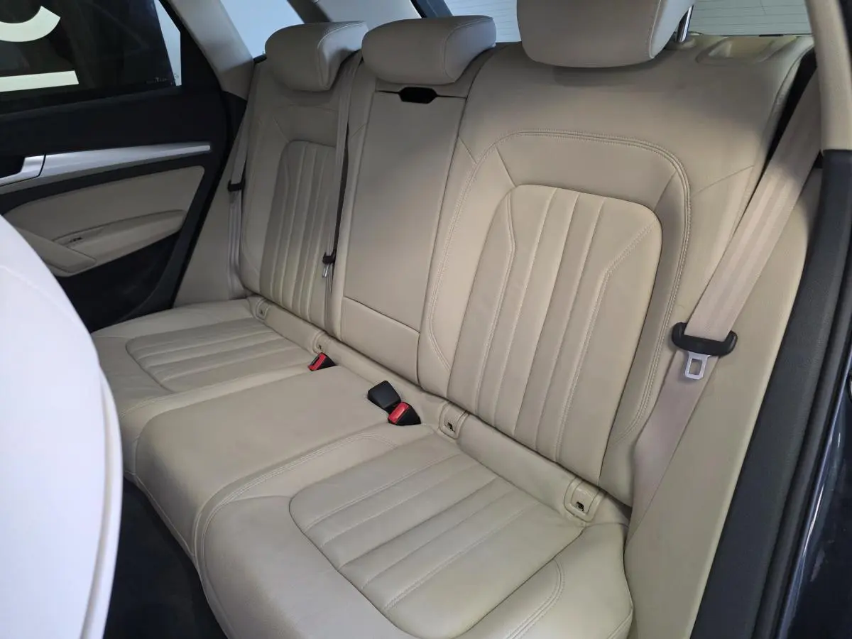 Vue latérale intérieure montrant la banquette arrière en cuir beige de l'Audi Q5 Business Executive 2019.