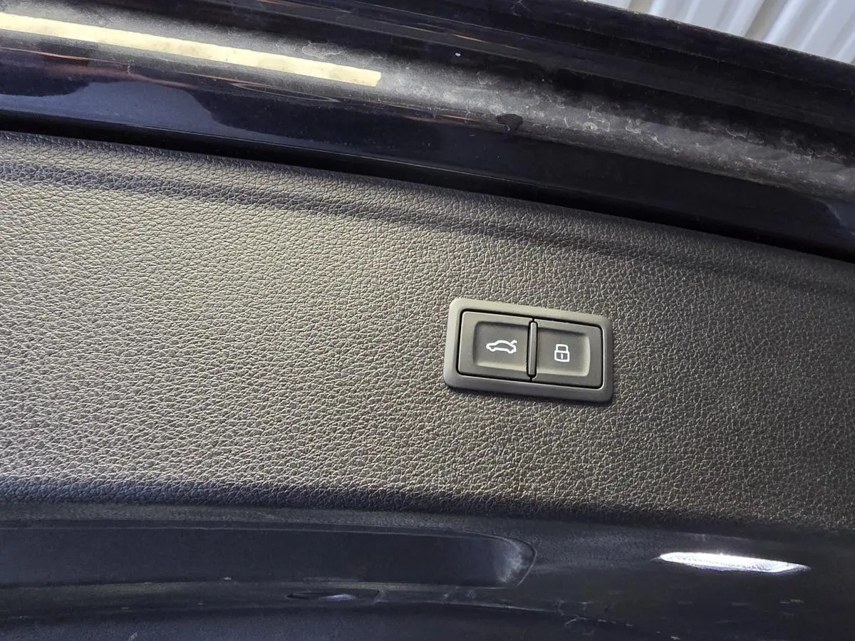 Boutons de commande pour ouverture et verrouillage du coffre sur la trappe intérieure d'un Audi Q5 bleu.